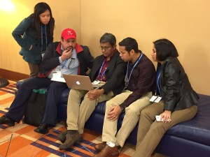 group of researchers looking at a laptop