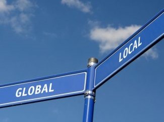 Intersecting street signs that read Global and Local