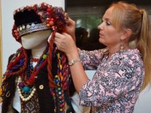 Woman putting a traditional Ukrainian headdress on a mannequin