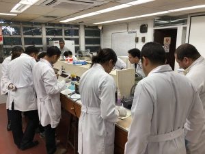 Students in lab coats in lab setting