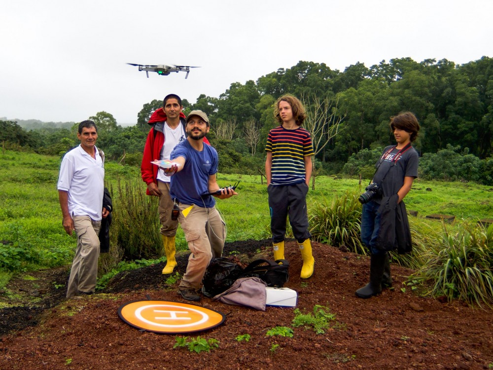 Group of people in field watching drone.