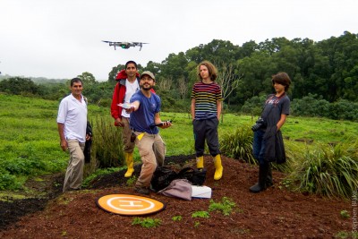 Group of people in field watching drone.