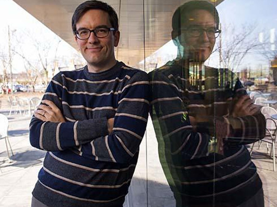 Man leaning against glass wall