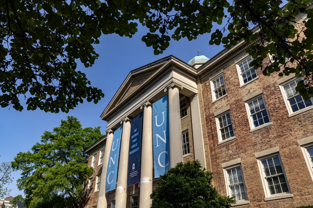 Banners that read "unc" hanging from a building with columns. The image creates a sense of grandeur.
