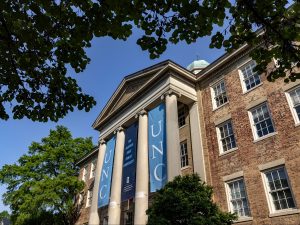Banners that read "unc" hanging from a building with columns. The image creates a sense of grandeur.