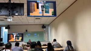 People watching a TV screen in a classroom.
