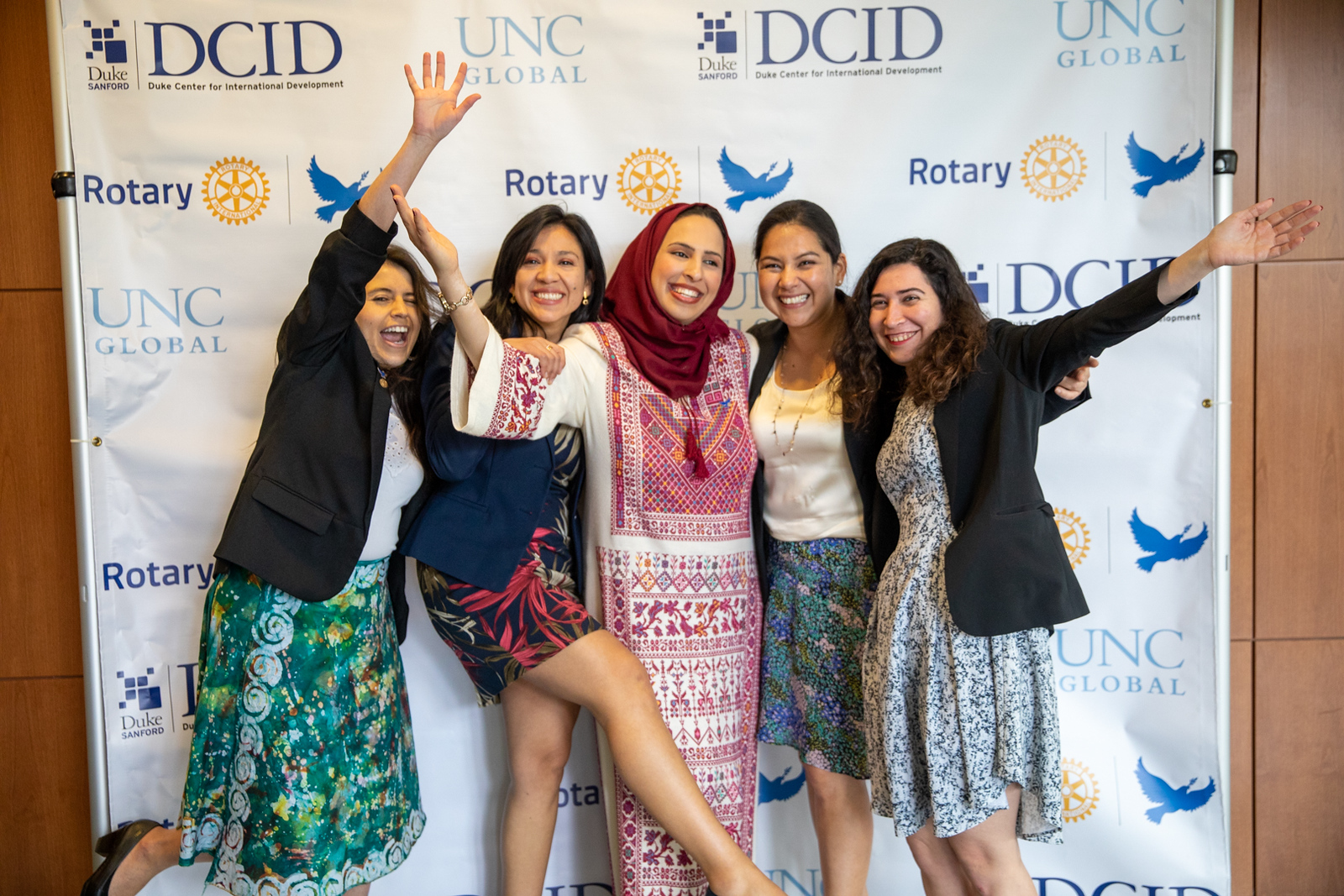 Five smiling women in front of a banner with the UNC Global, Rotary and Duke Center for International Development logos.