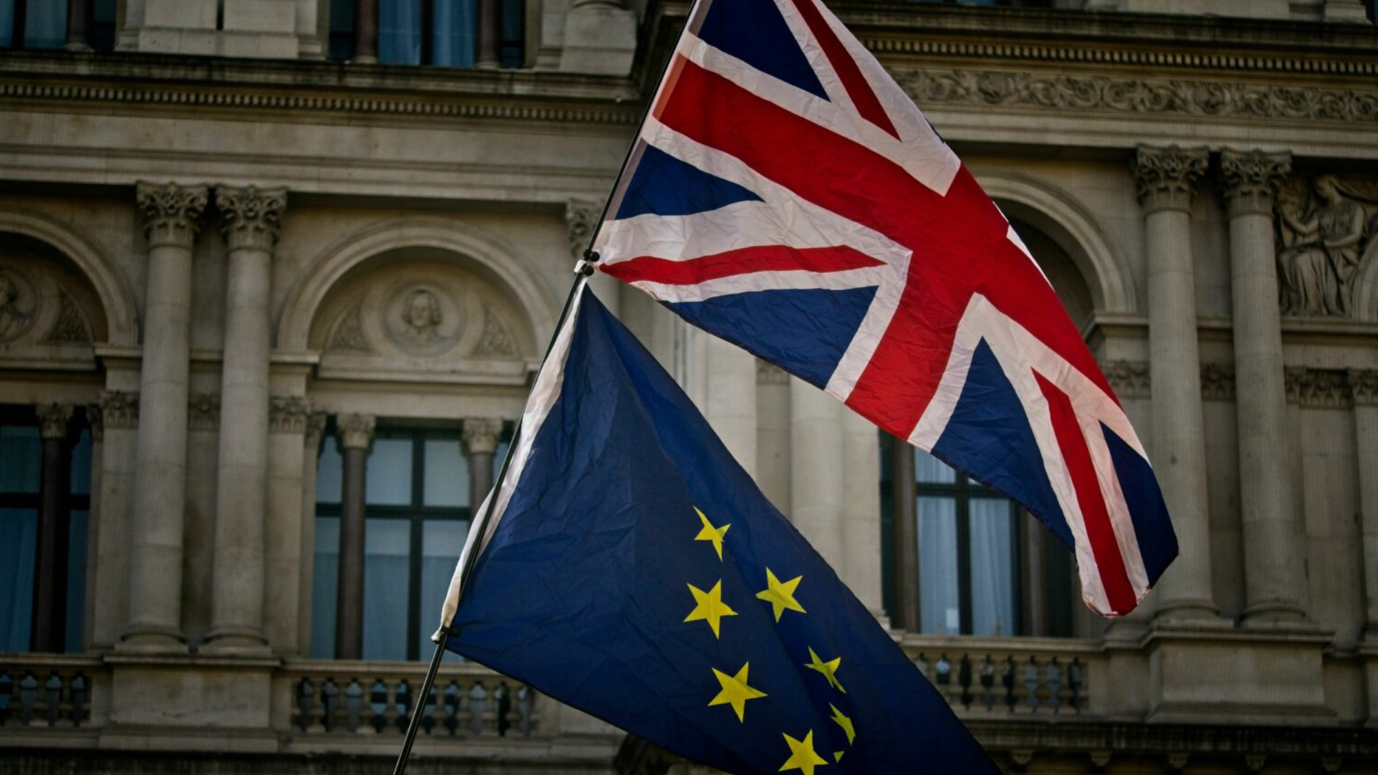 United Kingdom and European Union flags waving on a pole.