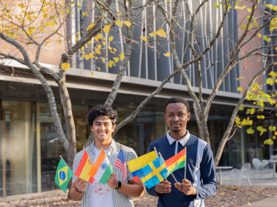 Two men holding small country flags